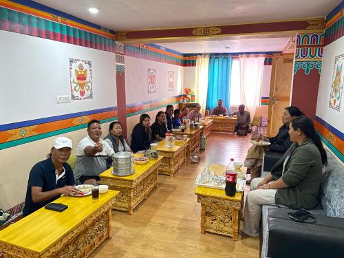 um grupo de pessoas sentadas em mesas em um restaurante em Gaywoo Guest House em Leh