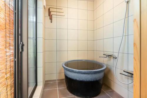 a bath tub in a bathroom with a shower at Minami Toji---JP Style Guesthouse in Kyoto in Kyoto