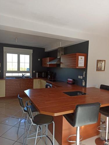 une cuisine avec une grande table et des chaises en bois dans l'établissement Maison, 5km de la mer, à Fontaine-Henry