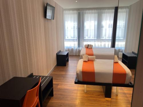 a hotel room with two beds and a table at easyHotel Lisbon in Lisbon