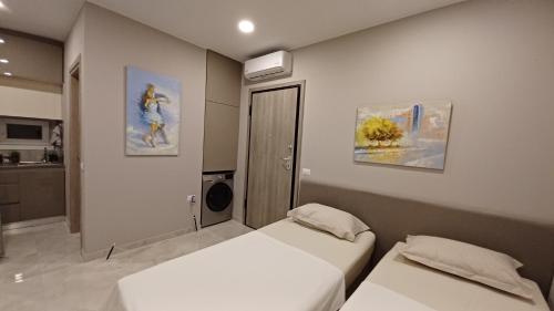 a bedroom with two beds and a kitchen at Κομψό studio με δωρεάν πάρκινγκ in Volos