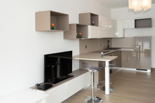 a white kitchen with a counter and a table at Serviced Apartments by Hotel de Charme Laveno in Laveno