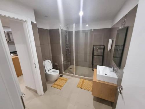 y baño con aseo, lavabo y ducha. en Luxurious 1 Bedroom Apartment Available en Accra