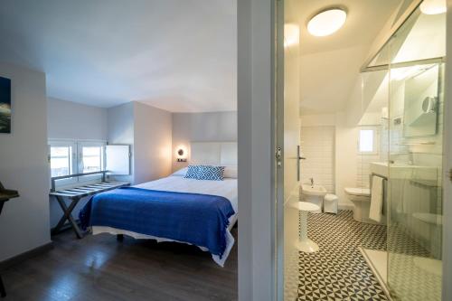 una piccola camera da letto con un letto e un bagno di Hotel&Spa El Puerto a Mundaka