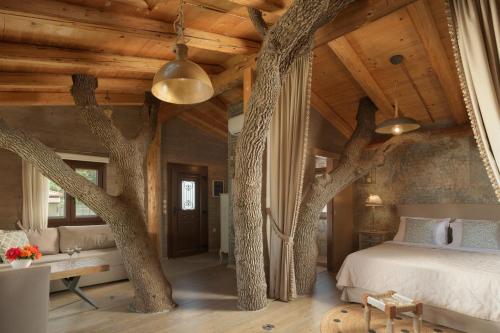 un dormitorio con árboles creciendo fuera del techo en Stolidi Mou Treehouse en Atsipopoulo