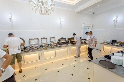 een groep mannen die in een keuken eten klaarmaken bij Konstantin Plaza in Samarkand