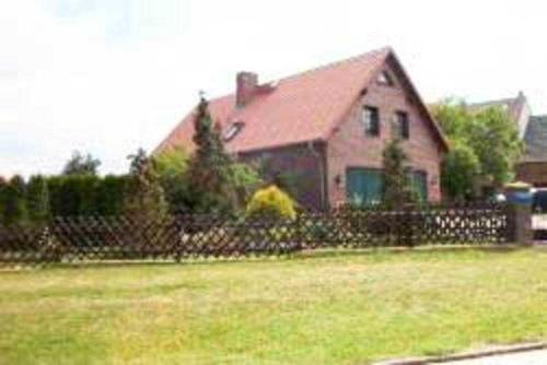 a house with a fence in front of a yard at Kraeuter_Landhaus in Bad Schmiedeberg