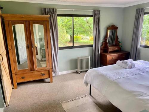 a bedroom with a bed and a dresser and a mirror at Windrush on Hogsback in Hogsback