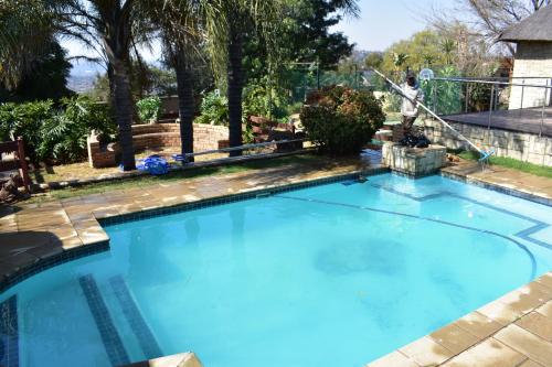 a large pool with blue water in a yard at 49 on Bristow in Roodepoort