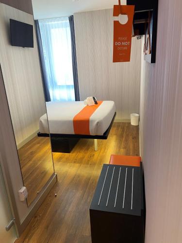 a small room with a bed and a bench in it at easyHotel Lisbon in Lisbon