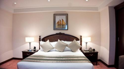 een slaapkamer met een bed met kussens en 2 lampen bij Luxurious Executive Room Available in Accra
