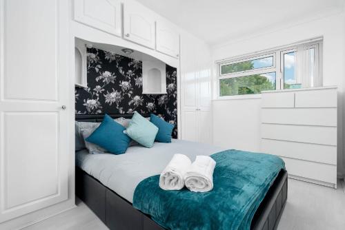 Un dormitorio blanco con una cama con toallas. en Modern 4 bedroom home ideal for Contractors, Groups and families ,FREE parking for multiple vehicle's en Birmingham