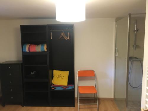 une armoire noire et une chaise dans une pièce dans l'établissement L'instant present, à Caen