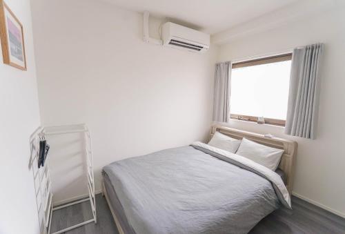 a white bedroom with a bed and a window at ZAITO Tokyo Skytree-Yokokawa II Studio 天空树旁舒适型民宿-宅东横II号店 in Tokyo