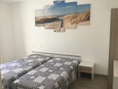 ein Schlafzimmer mit einem Bett und einem Wandgemälde in der Unterkunft Jolie maison sur Ors (Oléron) jusqu'à 6 voyageurs in Grand-Village-Plage