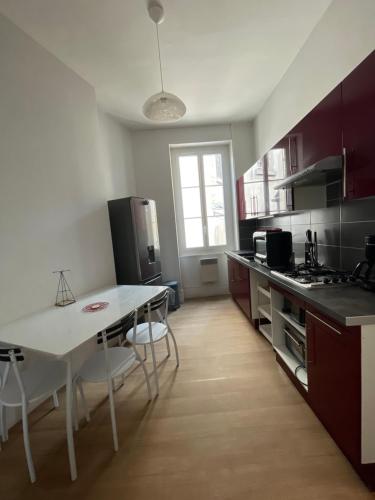 uma cozinha com uma mesa branca e cadeiras em Appartement standing em Nevers