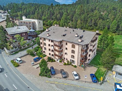an aerial view of a large building with a parking lot at La Planüra 15 in Maloja