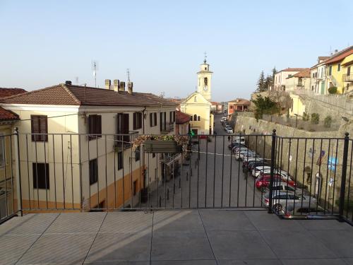 a view of a street with parked cars and a fence at La Piazza - Appartamenti Vacanza in Murazzano
