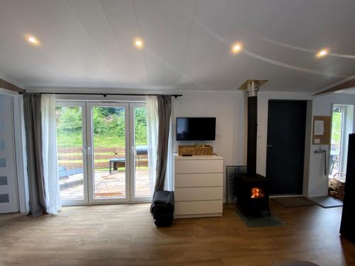 sala de estar con TV y chimenea en Tiny house, en Velké Karlovice