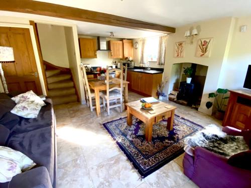 a living room with a couch and a table at Dove Cottage in Bisley