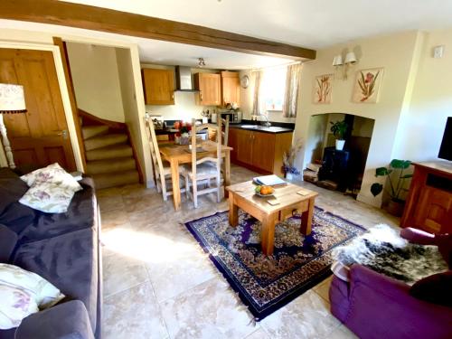 un salon avec un canapé et une table dans l'établissement Dove Cottage, à Bisley