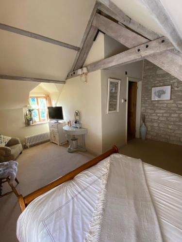 a bedroom with a bed and a sink in a room at Dove Cottage in Bisley