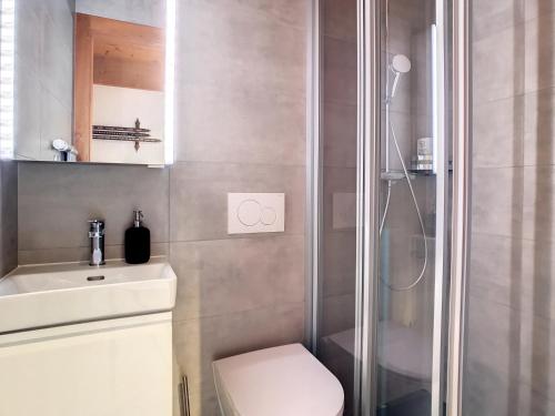 a bathroom with a shower and a toilet and a sink at Arolla 8 in Verbier
