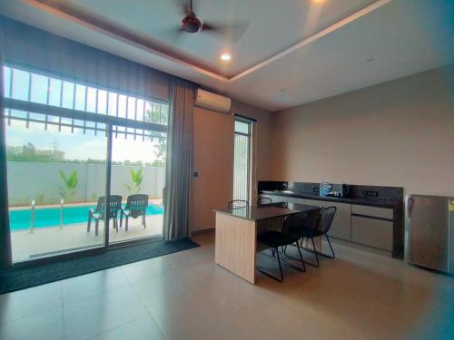a kitchen with a table and chairs and a pool at VAMA Retreats in Bangalore