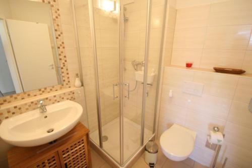 a bathroom with a shower and a sink and a toilet at Villa Gesine App 01 - Strandkorb in Nienhagen