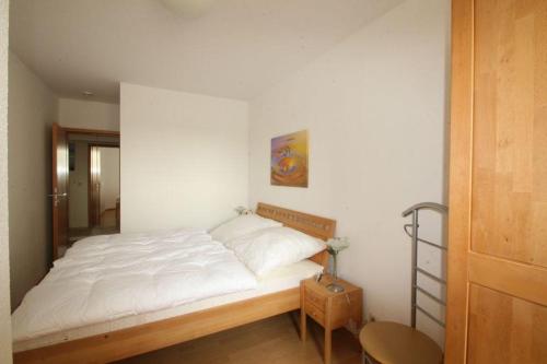- une chambre avec un grand lit et des draps blancs dans l'établissement Haus Odin App 24, à Graal-Müritz