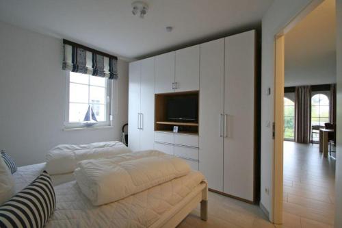 a bedroom with a large bed and a television at Villa Brigitte App 01 - Arielle in Nienhagen