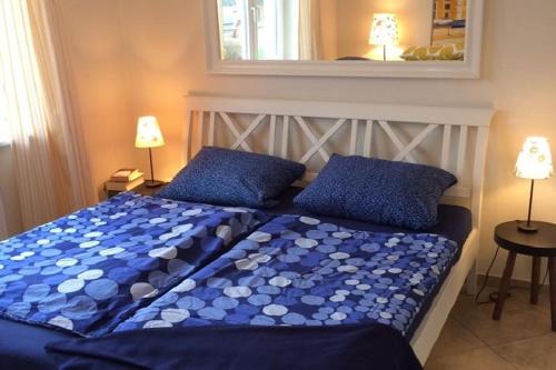 Una cama con sábanas azules y almohadas azules en un dormitorio. en Haus Undine App 01 Seeblick, en Warnemünde