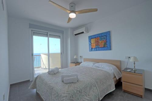 1 dormitorio con 1 cama y ventilador de techo en 069 - Panorama 001 - comfortHOLIDAYS, en Santa Pola