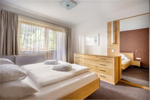 a bedroom with a large bed and a large window at Apartments Tschanun in Gaschurn