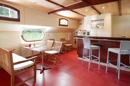 a room with a table and chairs in a train car at Péniche Daphné's in Auvers-sur-Oise