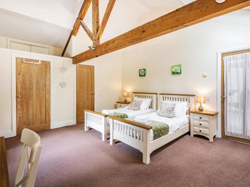 um quarto com 2 camas e uma janela em Hay Barn em Burton in Lonsdale