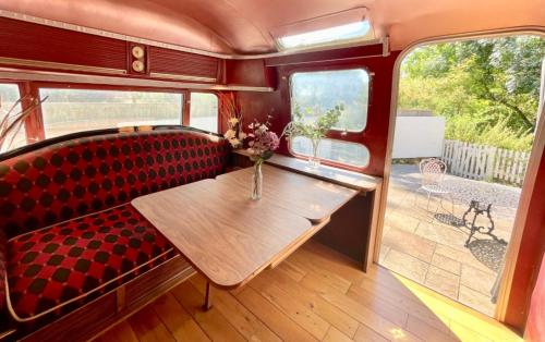 a dining room in a train car with a table at Airstream at Hardham West Sussex Sleeps 4 in Pulborough
