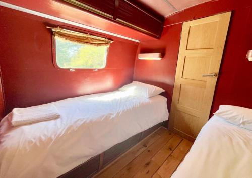 Habitación pequeña con 2 camas y ventana en Airstream at Hardham West Sussex Sleeps 4 en Pulborough
