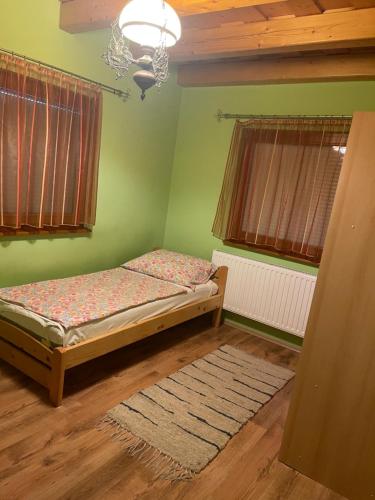バラトンベレーニにある4 hálószobás apartmanの緑の壁のベッドルーム1室(ベッド1台付)