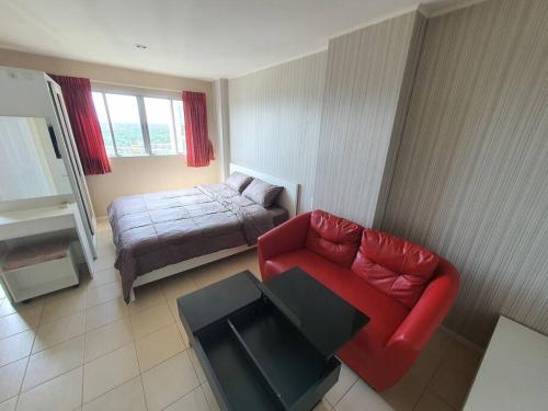 ein Wohnzimmer mit einem roten Sofa und einem Bett in der Unterkunft Cozy on Flr17 BKK view+Wifi+NearAirport @ Ramintra in Bangkok