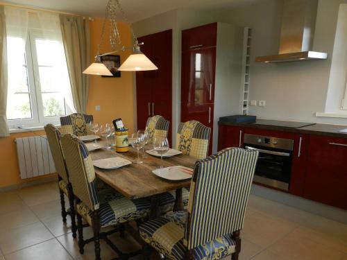 a dining room with a wooden table and chairs at Gîte La Grenouillère in Esquéhéries