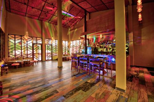 a restaurant with a bar with purple tables and chairs at Silver Sand Village Resort in Havelock Island
