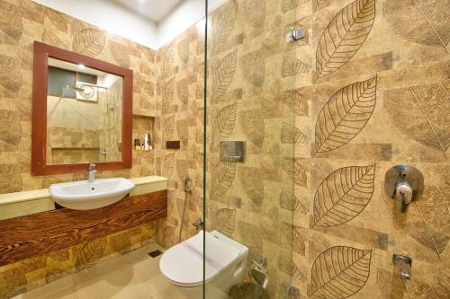 a bathroom with a shower and a toilet and a sink at Silver Sand Village Resort in Havelock Island