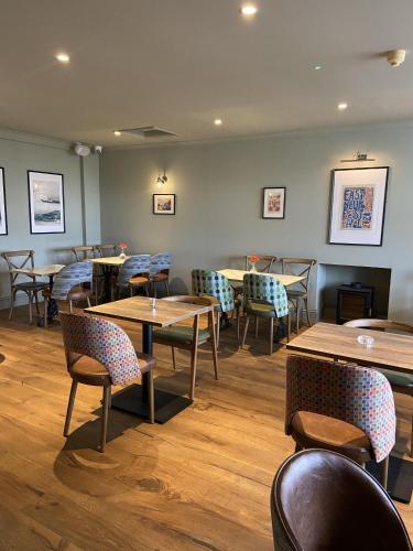 a restaurant with tables and chairs in a room at Balcomie Links Hotel in Anstruther