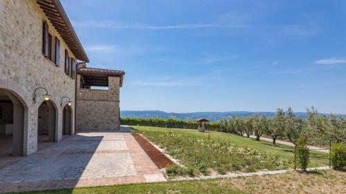 a building with a pathway next to a field and trees at LE RESIDENZE DEI POTTI 12, Emma Villas in Collazzone