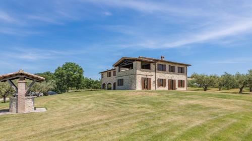 a large stone house on a grassy field at LE RESIDENZE DEI POTTI 12, Emma Villas in Collazzone