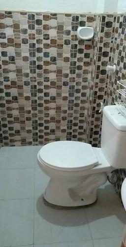 a bathroom with a toilet and a tiled wall at Villa Juan y Exequila in Anda