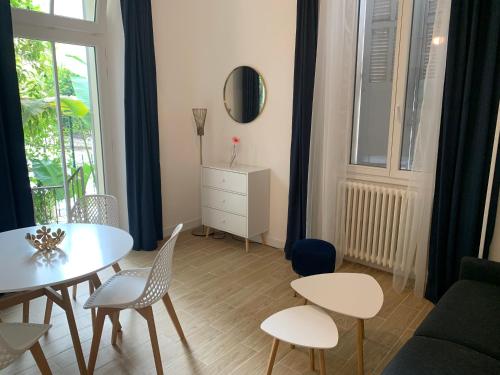 ein Wohnzimmer mit einem Tisch und Stühlen in der Unterkunft Villa Les Fougeres 2p jardin parking in Cannes