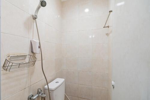 une salle de bain avec douche et toilettes dans l'établissement Urbanview Hotel Minongga Pondok Labu by RedDoorz, à Jakarta