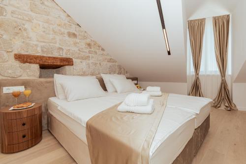 a bedroom with a large bed with towels on it at Trecento Boutique Rooms in Split